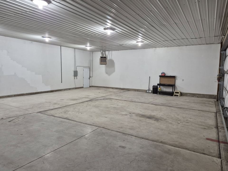 Empty hangar interior with a concrete floor and white walls