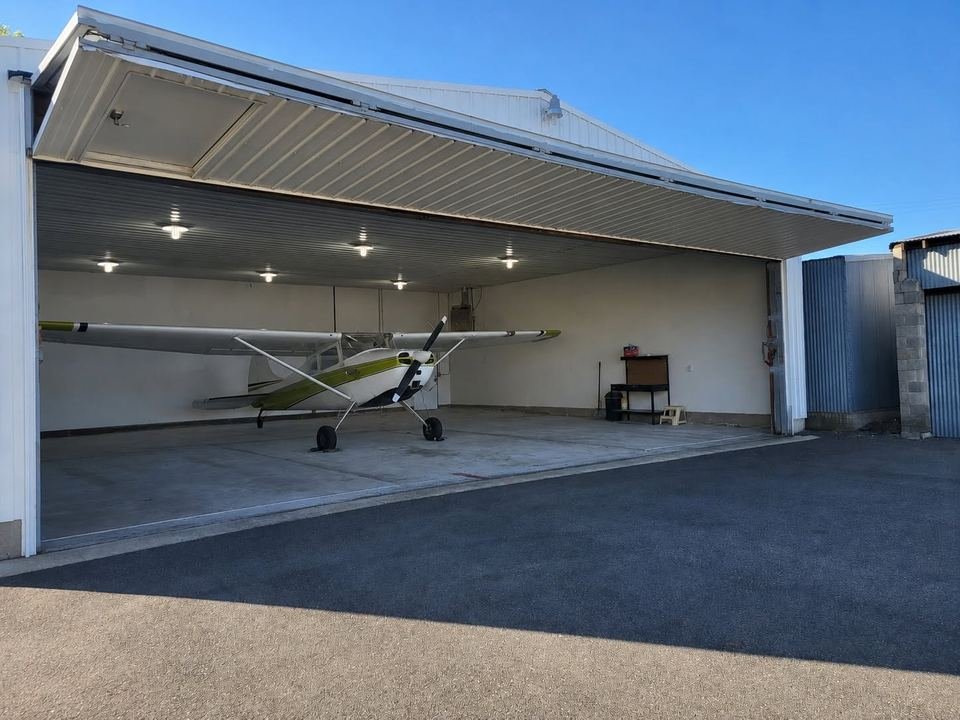 Single-engine airplane parked inside the open hangar
