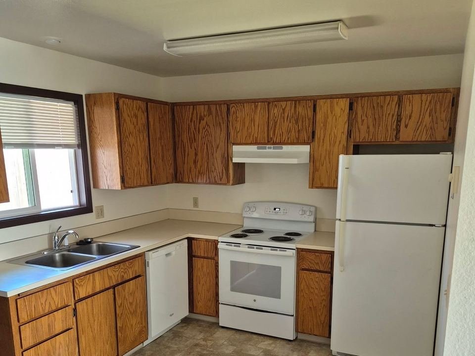 Kitchen with oak cabinets, range, dishwasher and refrigerator