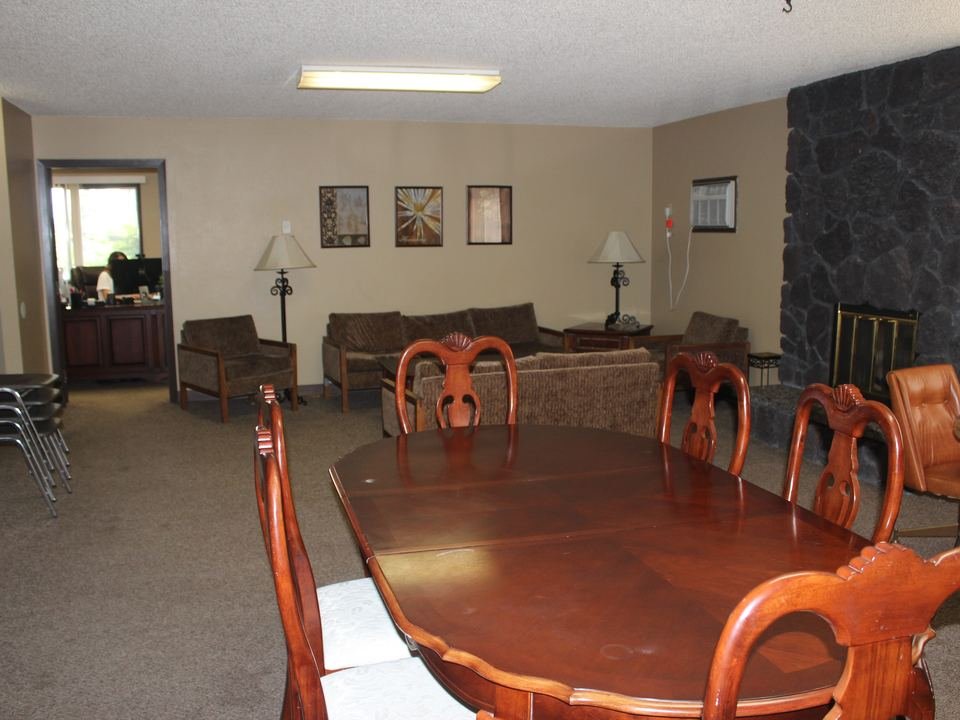 Clubhouse room with a dining table, sofas and a stone fireplace