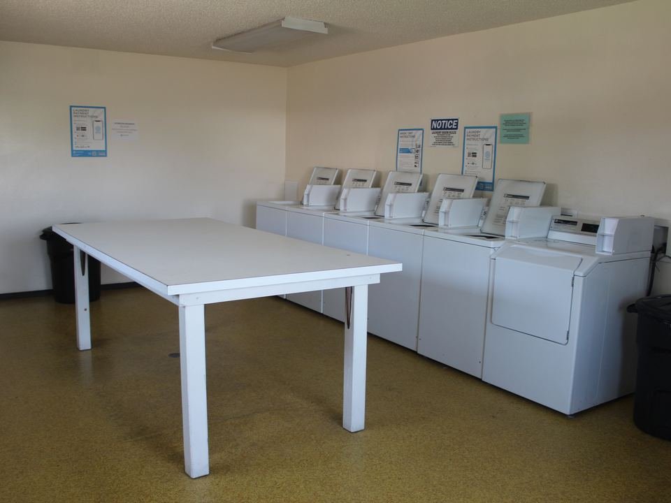 Laundry room with washers, dryers and a folding table